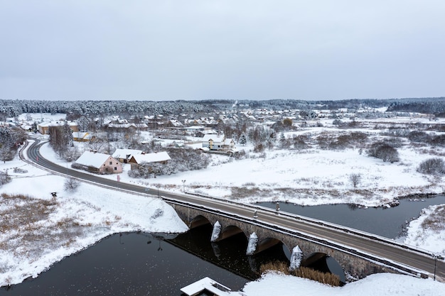 An old stone bridge with arches over the Abava river on a snowy winter day Kandava Latvia