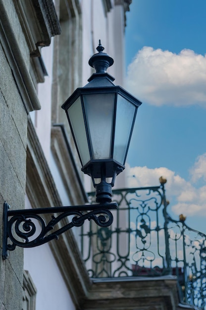 Old street lantern lighting on facade of building Twilight on city street building illumination Retro lantern lighting warm light glow Street lights illumination and vintage lantern