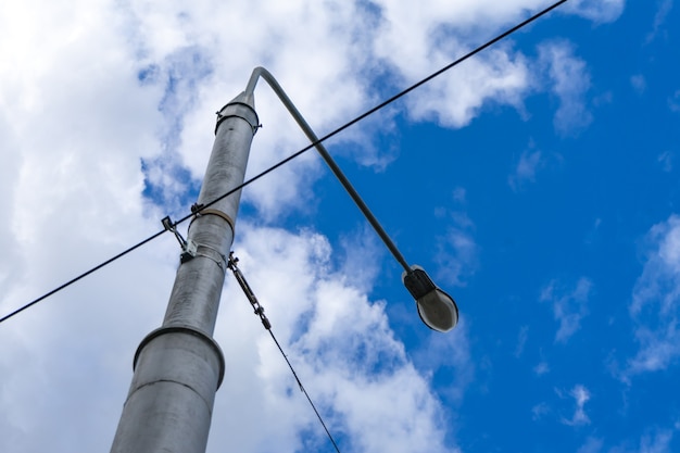 Old street light with many cables connected, isolated on gray sky. Copy space.