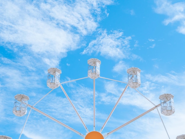 Old styled Ferris wheel against a blue sky with light clouds