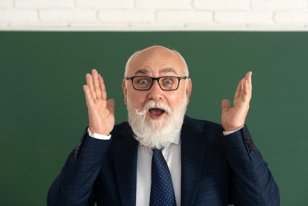 Old surprised face of funny teacher Excited senior professor on blackboard