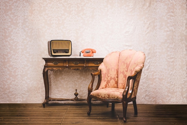 Old telephone radio and armchair in an interior place with retro style decoration