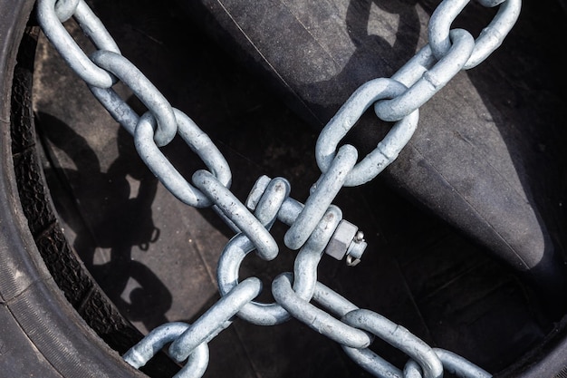 Old tires and rubber with chains and bindings for sea vessels and tugs piled up closeup