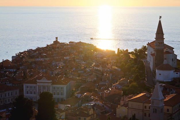 old town Piran against sunrise sky, Adriatic sea. Summer vacation. coast of Slovenia. Old Fountain