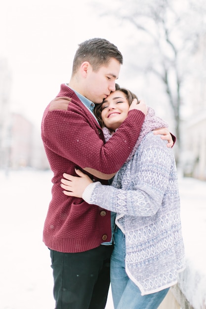  in old town. Young cheerful caucasian couple in warm cozy clothes walking in city centre.