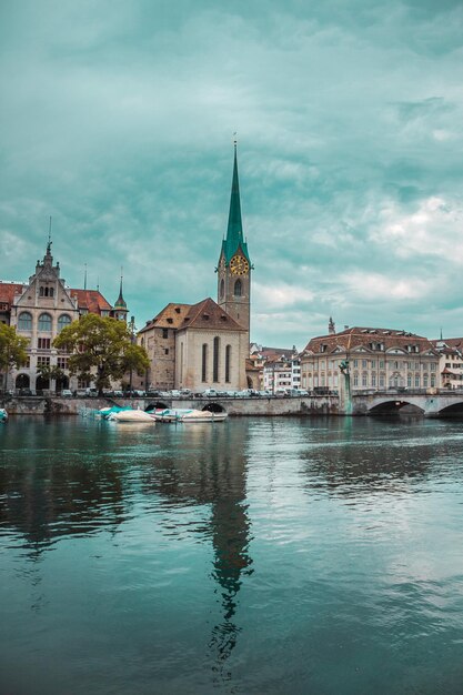 Old town in Zurich city Switzerland panorama of river bridge church with a spire and embankment