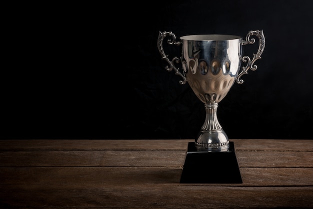 Old trophy on old wood with space of art dark background