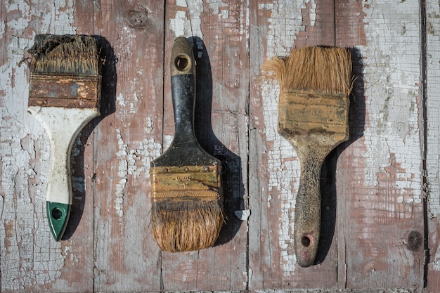 Photo old used brushes against the background of an old dried paint.