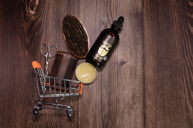 Old vintage barber shop tool on an old wooden background. Vintage wooden beard comb, beard oils.