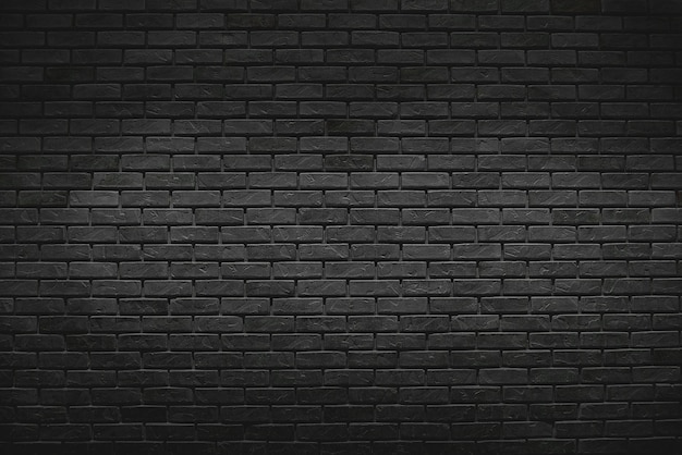 The old vintage black brick wall background with gradient light on surface