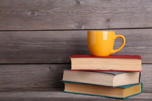 Old vintage books and cup on grey wooden table