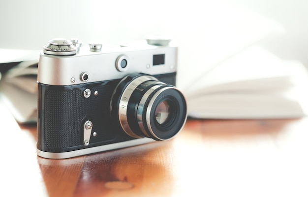 Old vintage camera with book on a wooden table