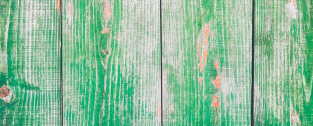 Old vintage green wooden planks of the house. Peeled wood texture, hipster background. Rustic village concept.