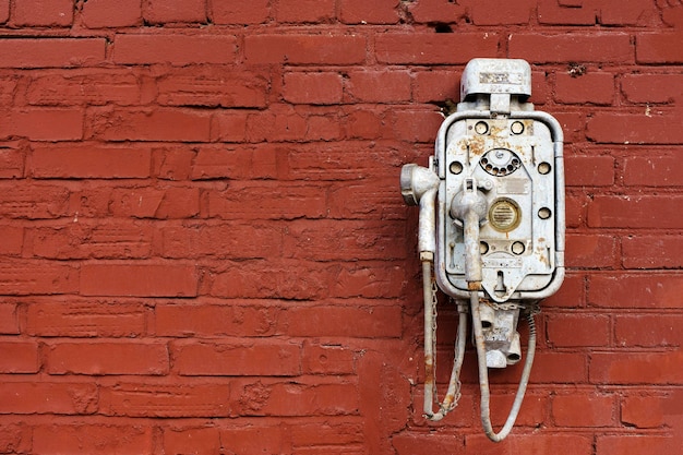 Old vintage telephone on a street brick wall Steampunk technology design retro style concept