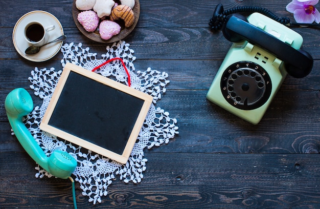 Old vintage telephone with biscotti coffee donuts on a wooden background