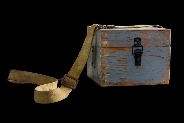 Old vintage wooden box on a canvas belt isolated on a black background