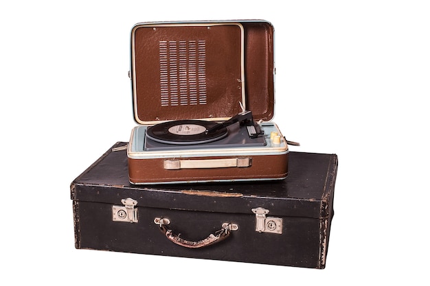 Old vinyl player on an old suitcase,  on a white