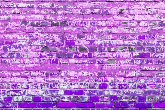 Old violet brick wall Peeling white paint on a violet wall