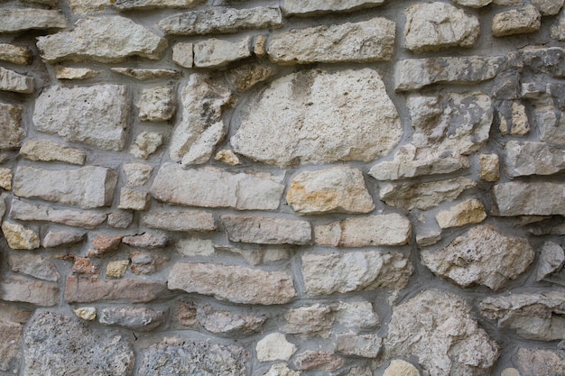 Old wall made of big stones and broken bricks. Vintage rough blocks surface background