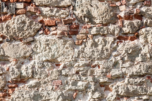 Old wall made of big stones and broken bricks