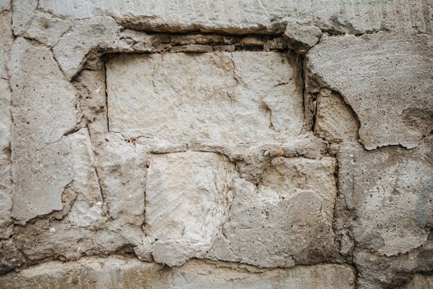 Photo an old wall that is collapsing, bricks visible, textured.