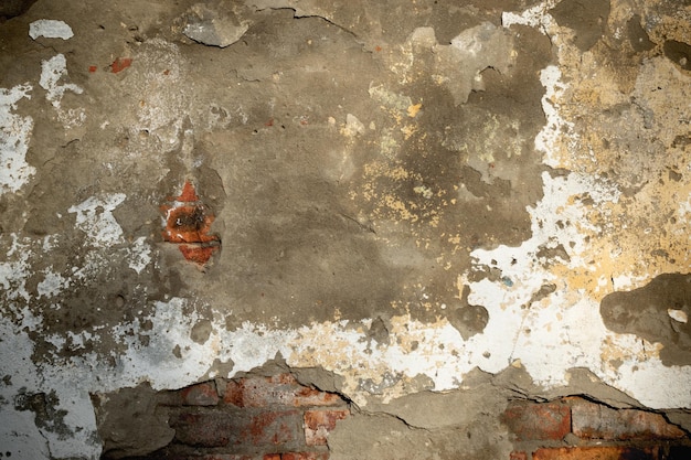 An old wall with fragments of cracked bricks and plaster Background image