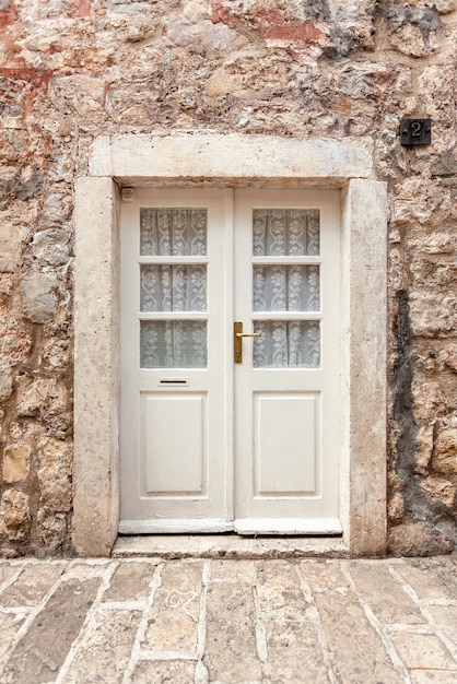 Old white classic door in ancient stone building