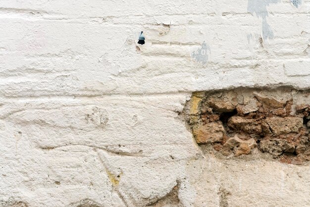 Old white wall with brown stones