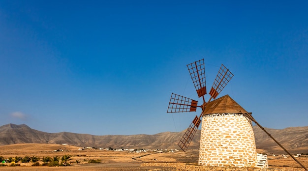 Old windmill on Fuerteventura island with the desert mountains in the background