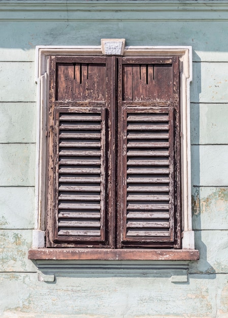 The old window with closed shutters on an old house