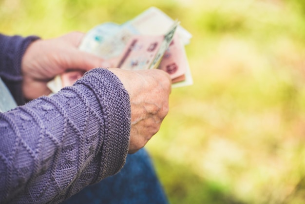 The old woman considers banknotes hands and money close up