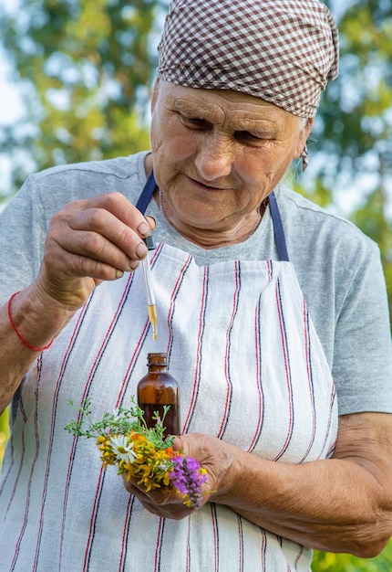 Old woman makes herbal tincture Selective focus