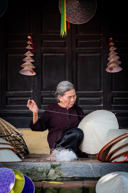 old woman making conical hats Vietnamese name is Non la Lang Chuong village Hanoi city Vietnam