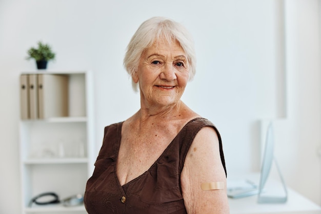 Photo old woman plaster on shoulder covid passport immunization safety