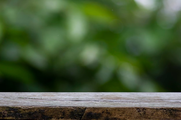 Old wood empty table for product display in front of green and yellow bokeh abstract background