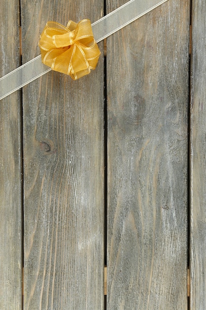 Old wooden background with beautiful bow