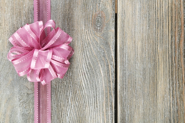 Old wooden background with beautiful bow