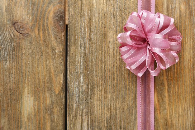 Old wooden background with beautiful bow