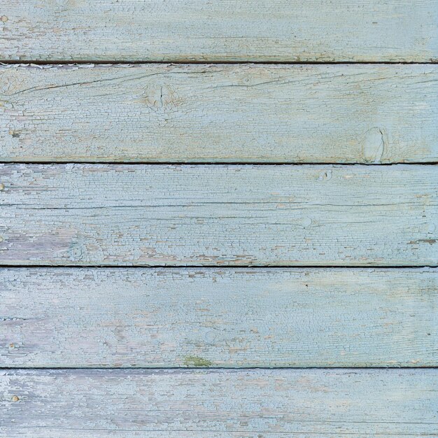 Old wooden boards painted in turquoise color Wall of an old wooden house in the countryside