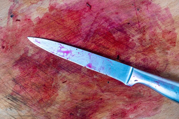 Old wooden cutting board and knife after slicing red beets in the kitchen