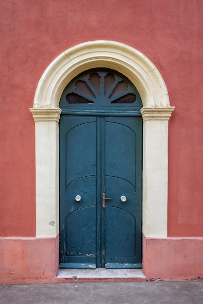 Old wooden entrance door on facade of antique baroque building in traditional architecture of Catania Sicily, Italy.