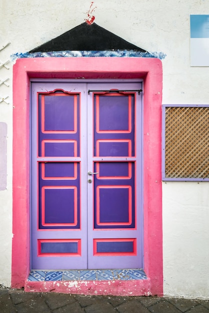 Old wooden entrance door on facade of antique baroque building in traditional architecture of Catania Sicily, Italy.