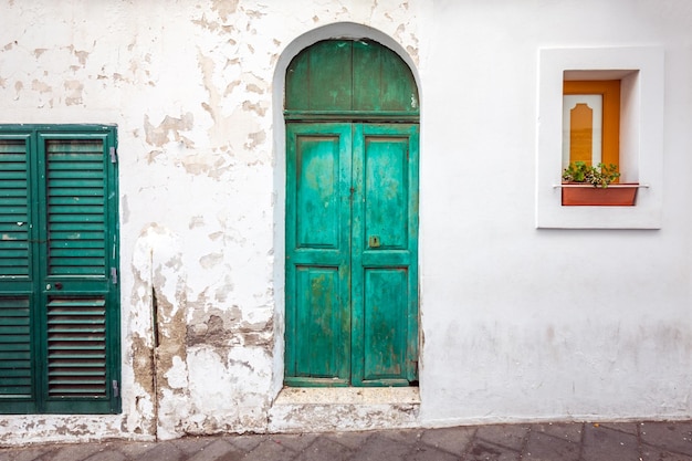 Old wooden entrance door on facade of antique baroque building in traditional architecture of Catania Sicily, Italy.