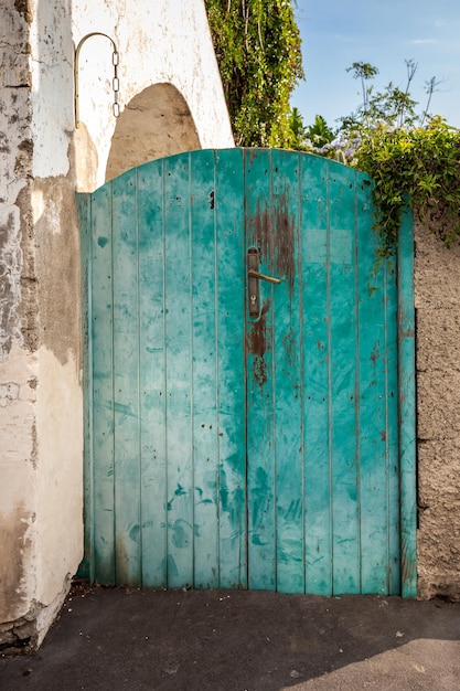 Old wooden entrance door on facade of antique baroque building in traditional architecture of Catania Sicily, Italy.