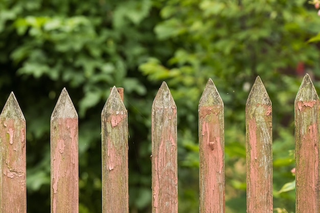 Old wooden fence with peeling red