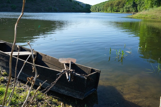 An old wooden fishing boat near the shore of the river Beautiful nature