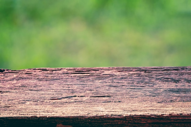 Old wooden table top on green nature background template display