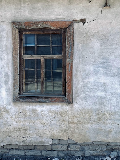 Old wooden window on the wall of an old house in the village