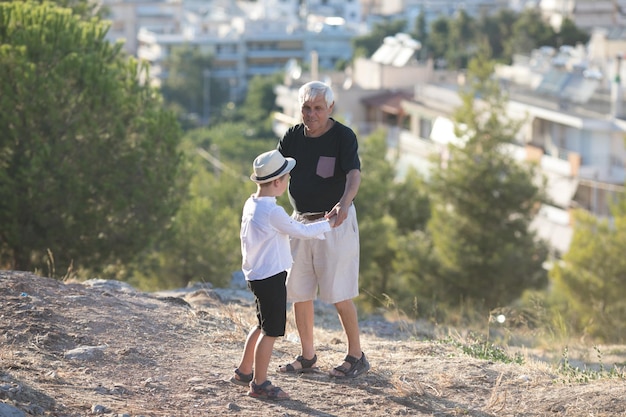 Old and Young Family generation and relations concept Retired grandfather and grandson playing with on sunny day enjoying outdoor