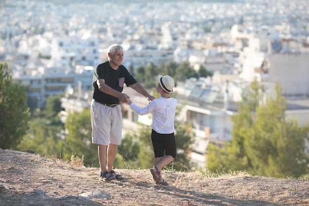 Old and Young Family generation and relations concept Retired grandfather and grandson playing with on sunny day enjoying outdoor